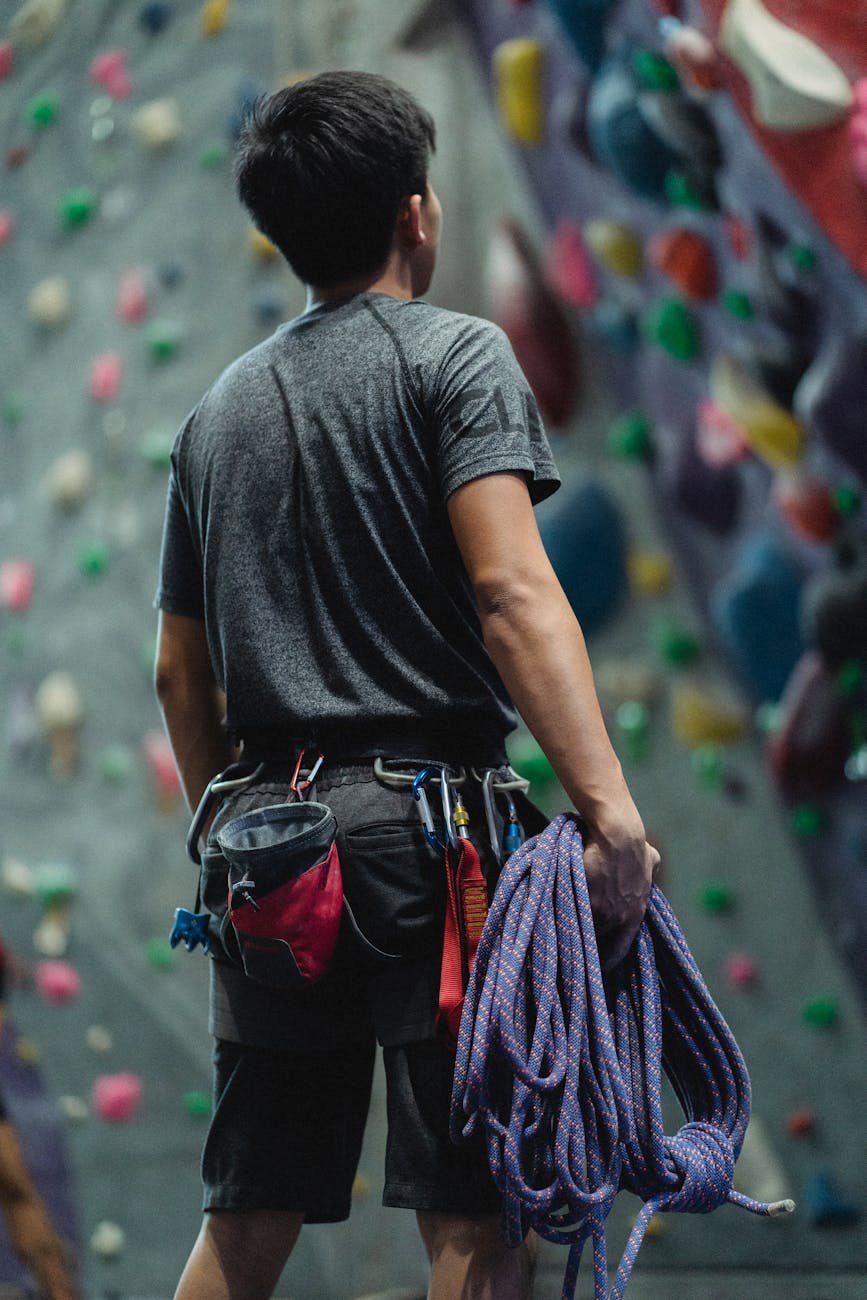 faceless athlete preparing rope for bouldering training in gym