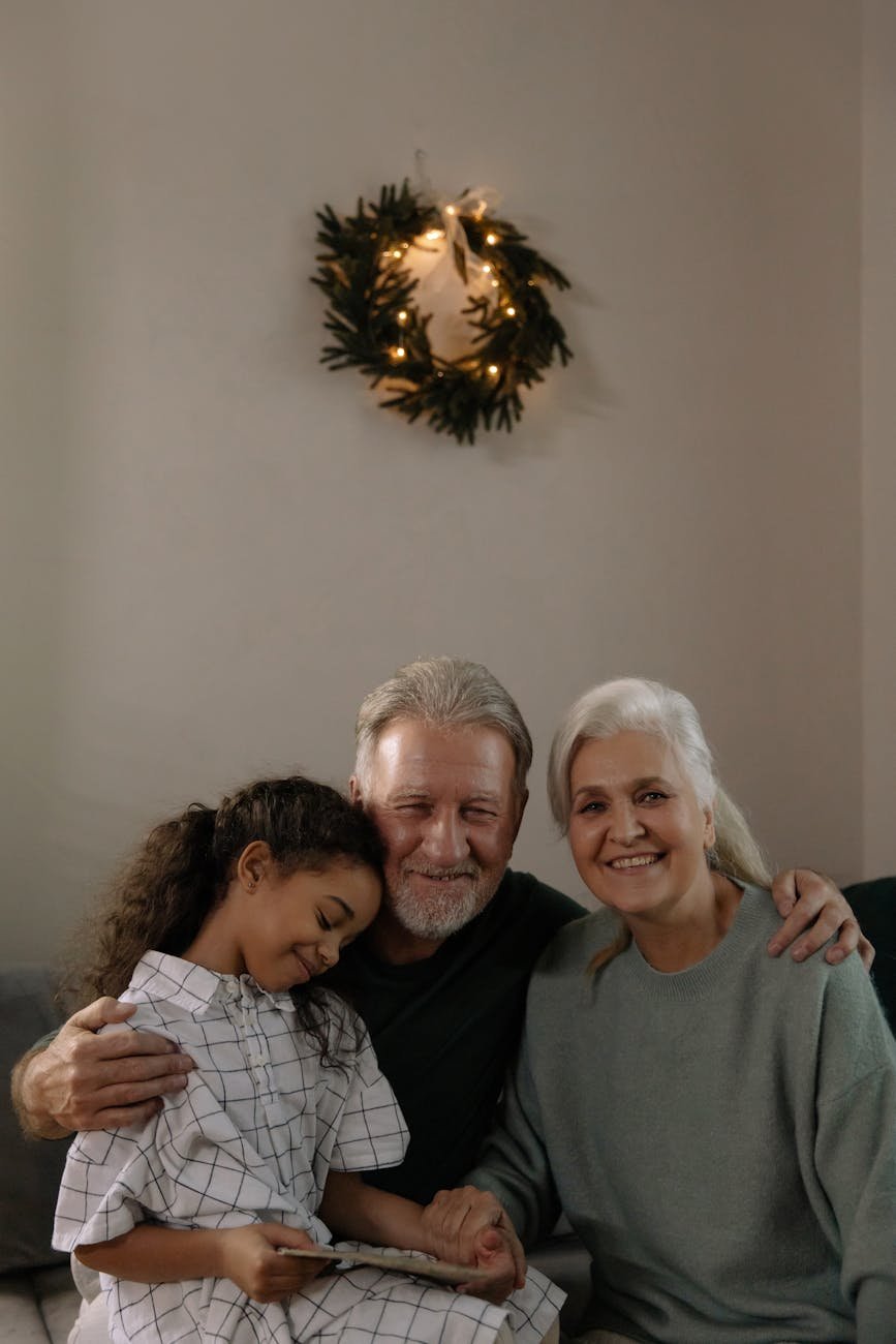 an elderly couple sitting with their granddaughter