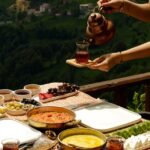 woman hands with tea over table with breakfast